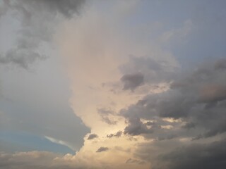 Obraz premium Dramatic evening sky with golden sunlight and dark storm clouds