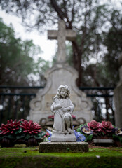 Obraz premium Small religious statue, memorial flowers in Marseille cemetery