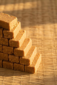 Pa&ccedil;oca peanut candy stacked on straw with warm sunlight and copy space