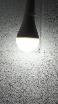 Male hand screwing in modern led Light bulb on light socket fixture at home