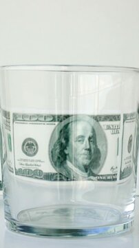 Water splash from glass with dollar bills background in concept of economic growth