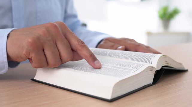 Hands, Bible study and man worship for religion, reading scripture and trust in God with story. Prayer, faith and spiritual closeup with holy book, learn Christian literature and gospel at home