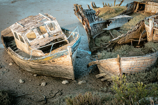 Abandoned  wrecks of wooden fishing boats on the shore on Noirmoutier island - France