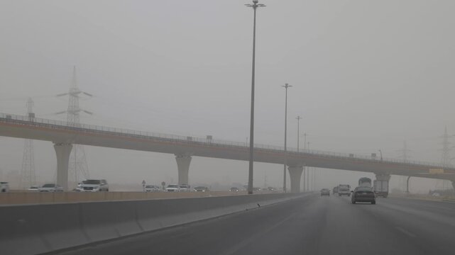Vehicles driving on a multi-lane highway under heavy fog in Al-Jouf Saudi Arabia during low visibility