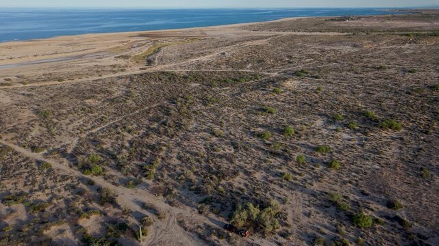 View of SUV with teardrop camper trailer at a camping spot by the ocean in Baja California, near the Sea of Cortez.
