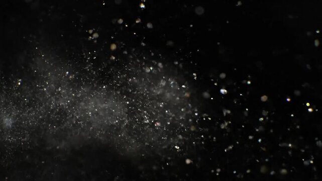 Sparkling Dust Particles Exploding in Slow Motion Against a Black Background, Abstract Artistic Texture