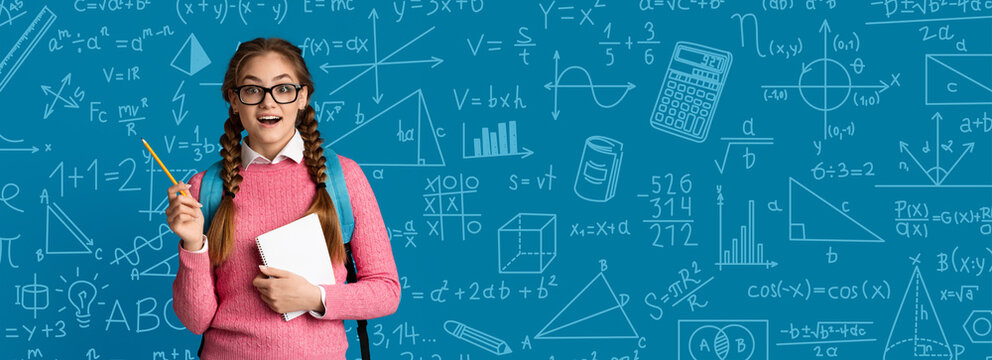 A girl stands in front of a blue chalkboard covered with math symbols and equations. She holds a notebook in one hand and a pencil in the other, looking excited about math.