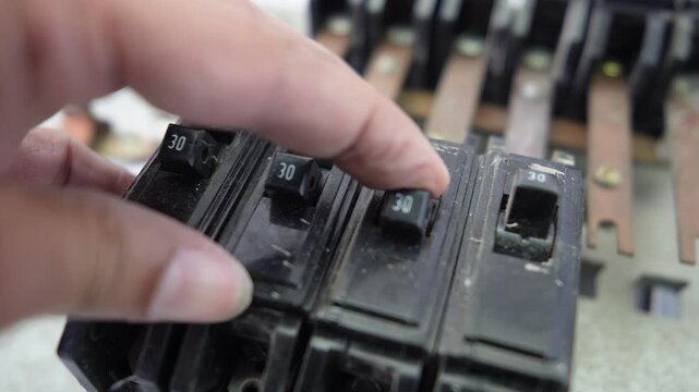 Hand handling old circuit breakers and electrical busbars