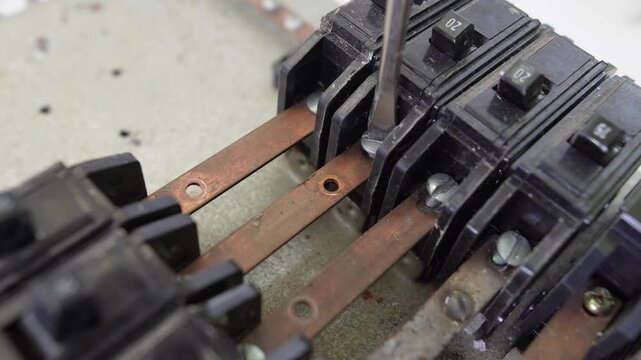 Hand handling old circuit breakers and electrical busbars