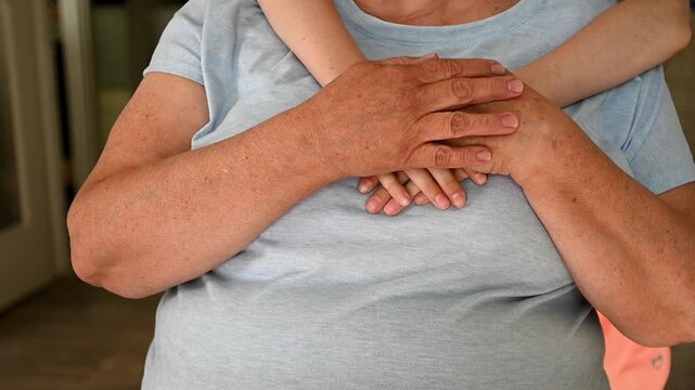 A child's arms embrace an elderly person. Different generations of the family. Grandeltern and grandchildren.