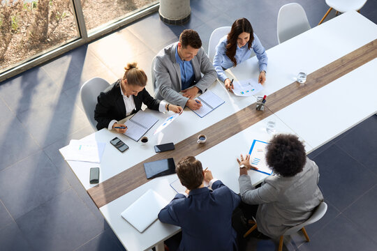 High angle view of group of business people working on reports in the office