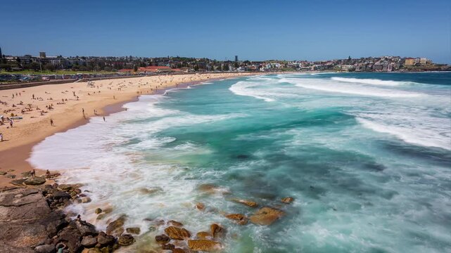 Timelapse clip of beautiful Bondi beach in Sydney, Australia with the waves crashing on the shore while people are on the beach