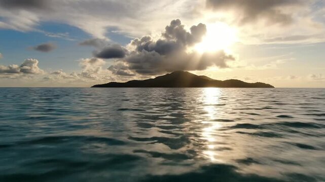 Sunset over tropical island with sunbeams through clouds