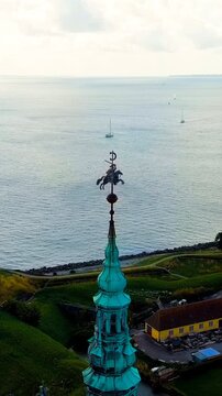 Vertical video. Helsingor, Denmark. A 16th-century castle with a banquet hall and royal chambers. The prototype of Elsinore Castle in the play Hamlet. Drone footage, Departure of the camera. Rich col