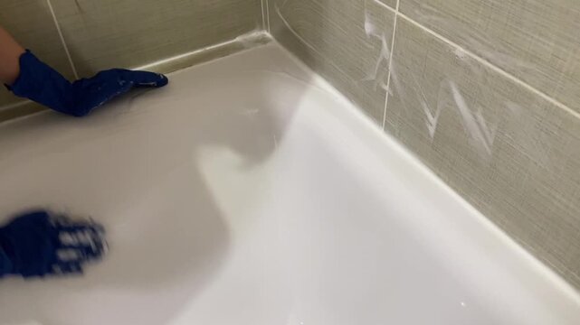 Hands working on tile grout cleaning, Removing residue from tile edges and sealing joints meticulously, Carefully scrubbing grout and sealing lines at tile edges for tidy appearance