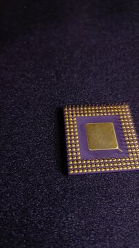 Vertical 9:16 pan of an old purple CPU with thick gold-plated pins on black background. Ideal for mobile-first TikTok content, vintage 1990's computer tech, gold recovery, and e-waste recycling.
