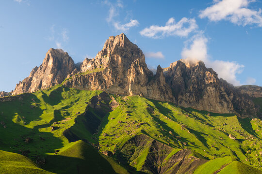 Aktoprak pass in North Caucasus, Russia. Green mountains and the blue sky at sunset. Clouds over the rocks.