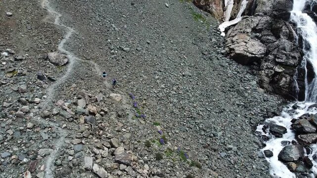  High angle view of hikers on zig zag trail on steep rocky scree slope, extreme trekking, Tian Shan mountains, Kyrgyzstan, Karakol. High quality 4k footage