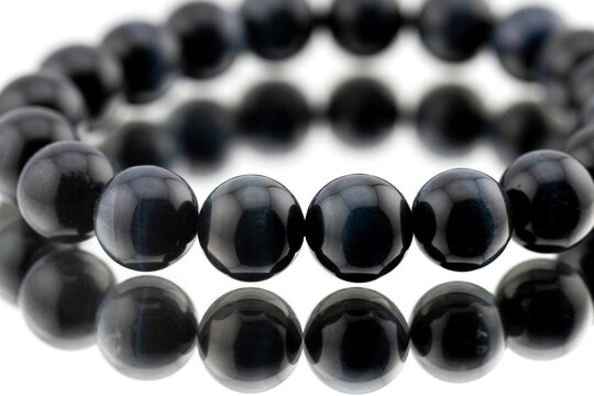 Close up of blue tiger eye gemstone beads for jewelry making on dark background