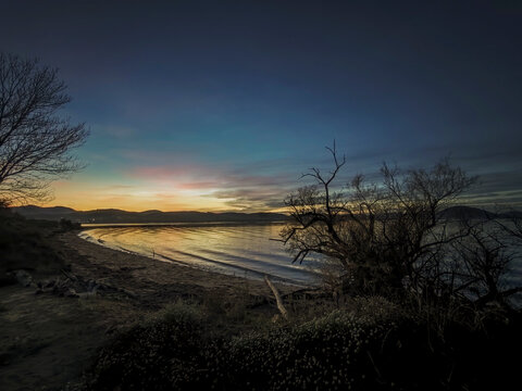 Tranquil beach shoreline at twilight with mountains