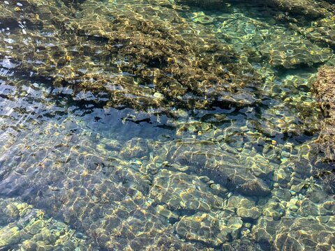 Transparent sea water with underwater stones and pebbles.