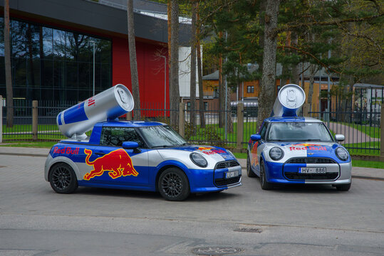 Valmiera,Latvia-May 10,2026-Red Bull branded Mini Cooper cars with giant tin cans parked outside Jānis Daliņ&scaron; Stadium.