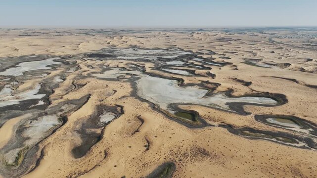Aerial view of white salt pans and vast desert landscape in the Al-Jouf Saudi Arabia region