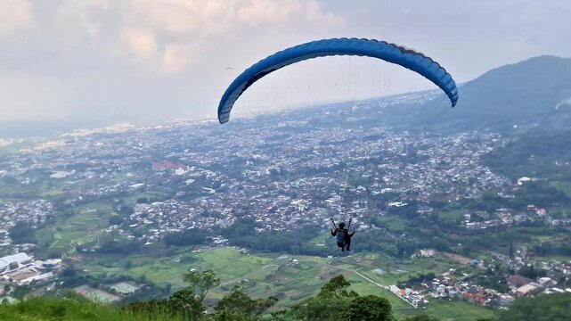 Malang, Indonesia - 3 May, 2026: Professional Tandem Paragliding Takeoff and Flight Over Scenic East Java