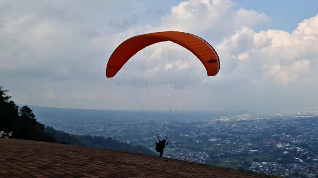 Malang, Indonesia - 3 May, 2026: Professional Tandem Paragliding Takeoff and Flight Over Scenic East Java