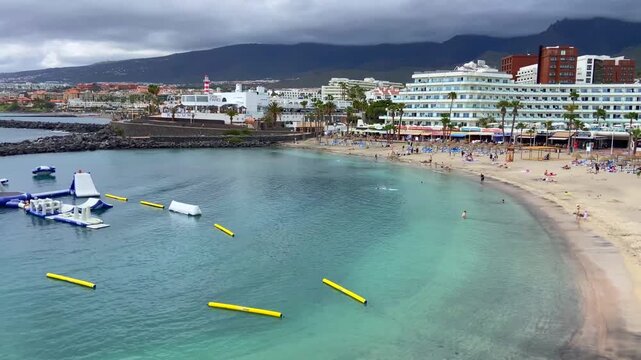 View of Playa La Pinta in Puerto Colon, Tenerife,
Canary Islands, Spain. It is a small beach with volcanic sand, calm waves and transparent water,4K