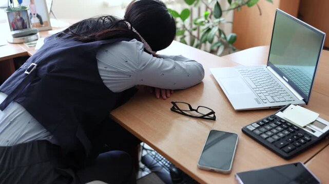 Business woman in a mask blindfolded asleep in the office. Exhausted employee in the workplace