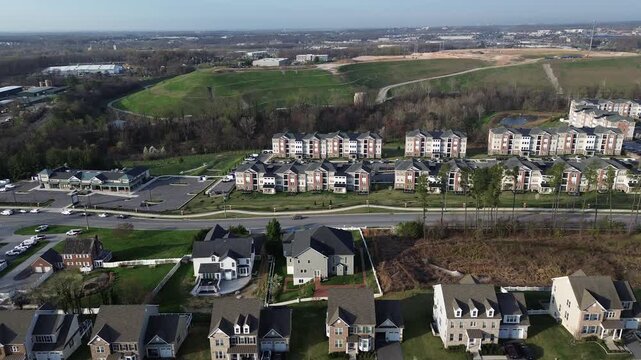Hillside residential span captures aligned homes near Straw Lily Way with midrise apartments open green slopes extending toward White Marsh commercial edge, Maryland