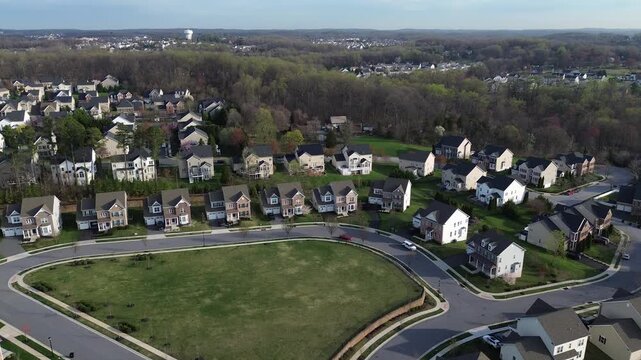 Open green corridor frames homes circling central lawn along Straw Lily Way near Forge Road with wooded edges extending toward Gunpowder Falls, Maryland