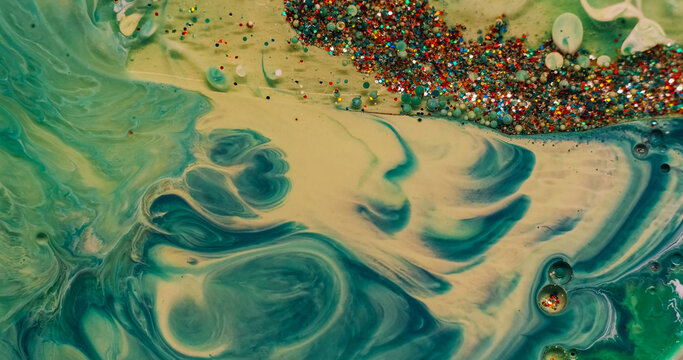 Color paint water. Sequins background. Defocused green bubble acrylic marble oil splash round texture flowing on creative art abstraction.