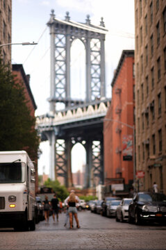Two Pedestrians Navigate Ancient Bridge Amid Old Industrial Warehouses new york