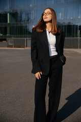 Obraz premium Beautiful Business Woman Standing Confidently Near Modern Office Building Wearing Black Suit And White Shirt. Corporate Lifestyle Concept Female Professional Urban