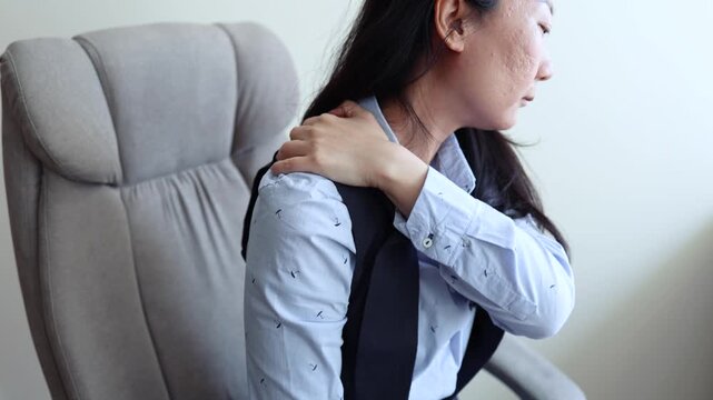 Neck pain at work. Tired Asian businesswoman feeling exhausted, neck and shoulder muscle ache, healthcare and office syndrome concept. Stressed woman sitting at laptop and holding painful neck with ha