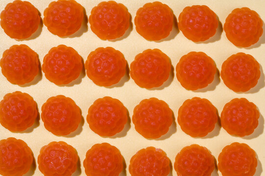 Jelly gummies close-up, fruit vitamins raspberry shaped, food supplements.Orange vitamins candies, top view