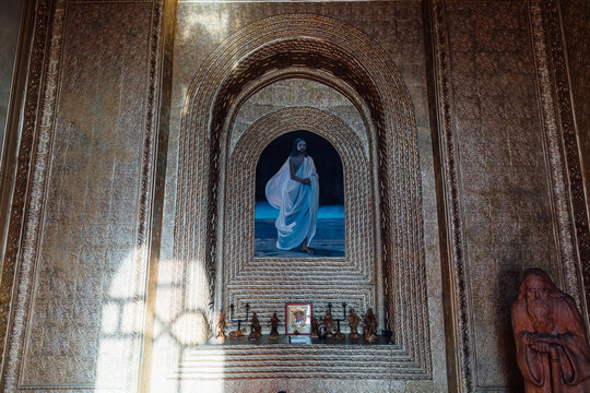 Ornate interior detail at the Rukh Ordo cultural complex in Cholpon-Ata, Issyk-Kul Region, featuring a religious painting, carvings and warm light