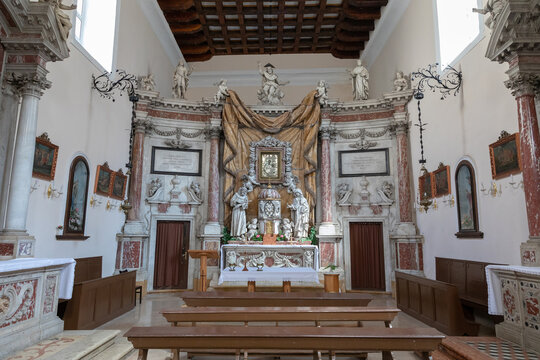 Wide view of the ornate altar and nave inside St Nicholas Church in Kotor, Montenegro, featuring baroque sculptures, marble columns, wooden pews and framed icons