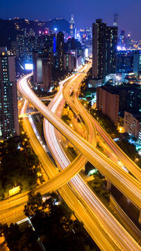 Busy city highway interchange with night vehicle light trails.