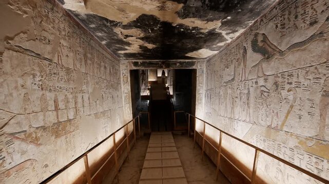Narrow descending staircase inside an ancient Egyptian royal tomb, KV17 tomb of Seti I, Valley of the Kings, Luxor, Egypt, with faded hieroglyphic paintings on ceiling, illuminated stone walls and woo