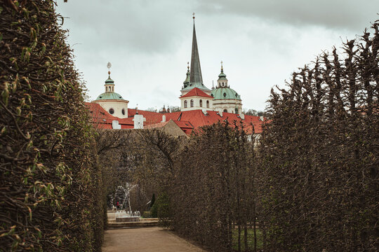 Scenic view of historic church towers and red roofs from Wallenstein Garden in Prague, Czech Republic