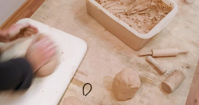 Clay molding. Handmade hobby. Unrecognizable specialist woman hands forming raw for ceramic crockery in professional workplace.