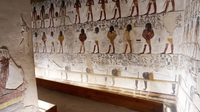 Close-up of ancient Egyptian relief carving inside KV17 tomb of Seti I, Valley of the Kings, Luxor, Egypt, showing a deity figure with black hair and deteriorating pigment.