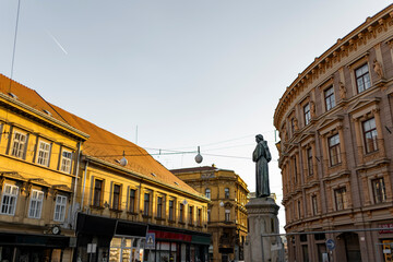 Fototapeta premium Historic Zagreb street with statue and classical architecture during golden hour Croatia