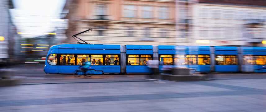 Blue public tram in motion on Zagreb street during evening rush hour Croatia