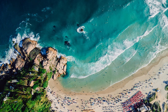 Joaquina beach in Florianopolis with rocks and ocean with waves. Aerial photo