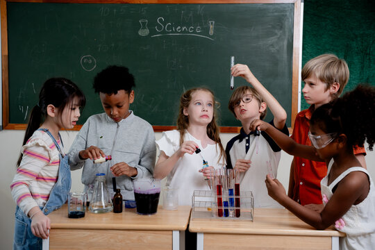 Education concept. Diverse elementary students conducting science experiment in classroom laboratory. test tubes, colorful liquid, promoting STEM education, teamwork, curiosity, learning. education