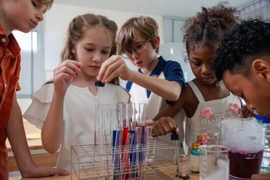 Education concept. Diverse elementary students conducting science experiment in classroom laboratory. test tubes, colorful liquid, promoting STEM education, teamwork, curiosity, learning. education
